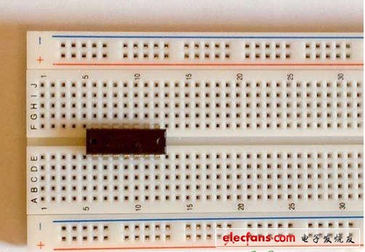 在面包板的中間插入TLC3704集成電路（IC）芯片。